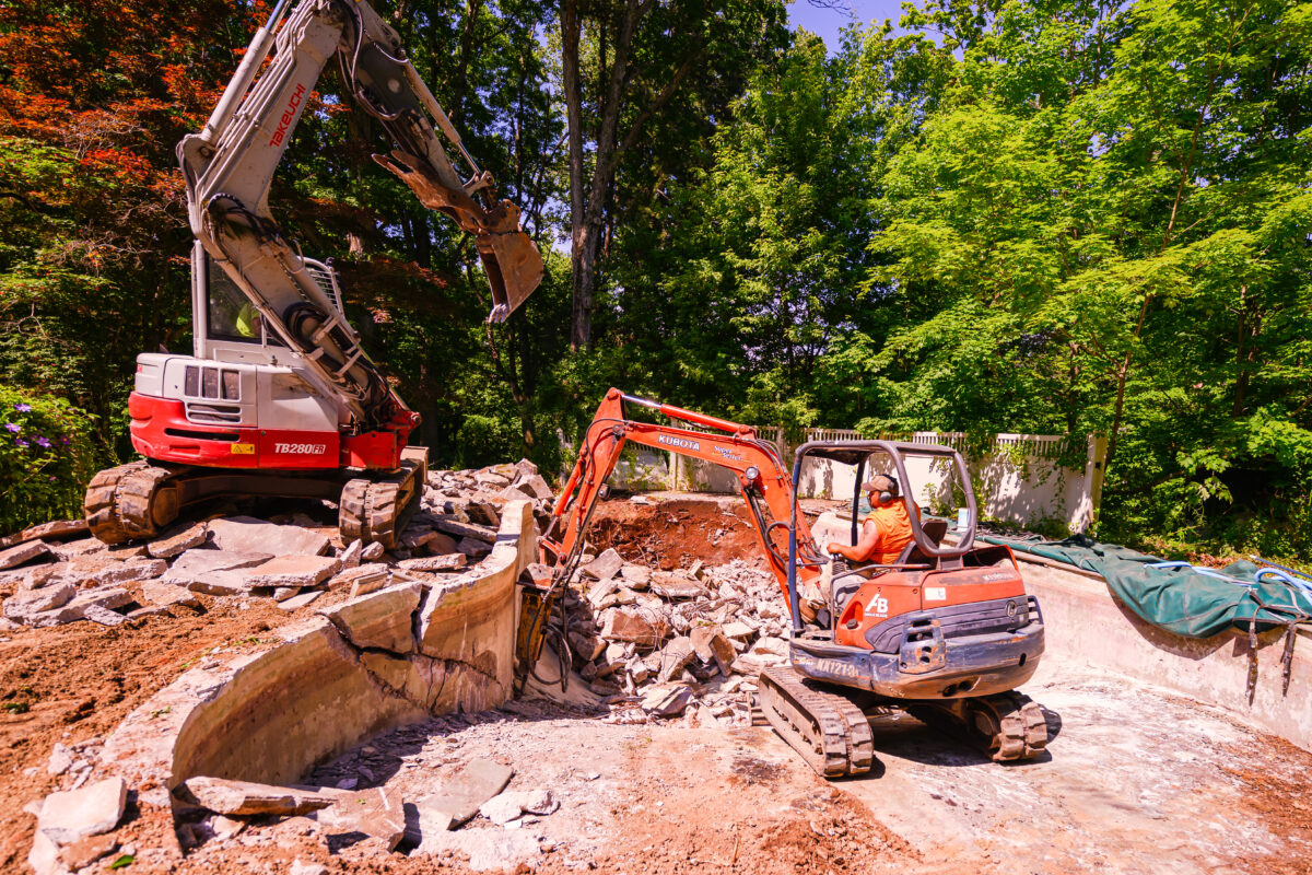 Concrete pool demolition with equipment staging and broken concrete material handling