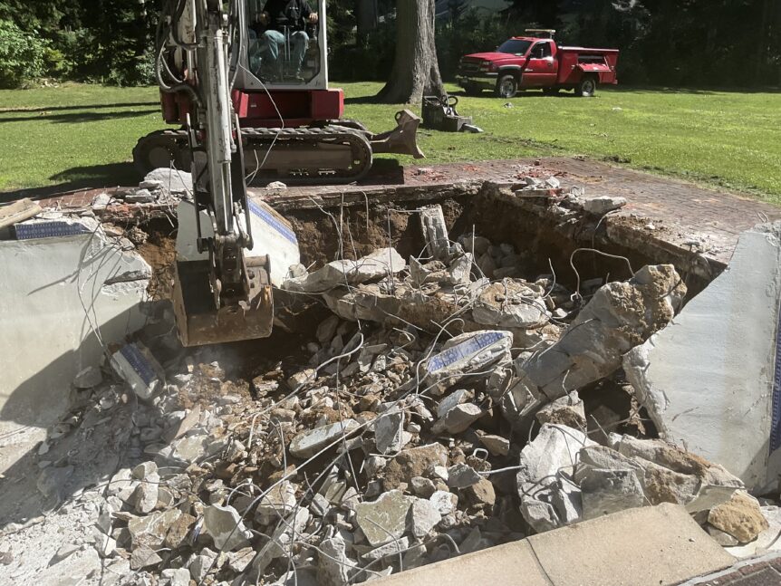 Gunite pool demolition in Wilton CT showing broken concrete shell and exposed rebar