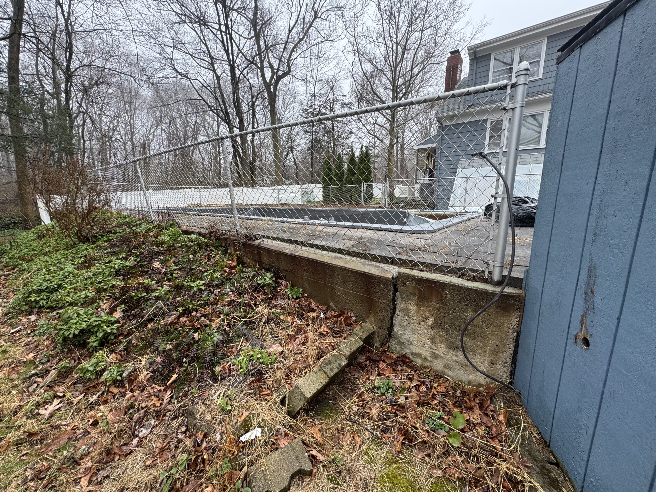 Before: fenced in-ground pool area prior to demolition